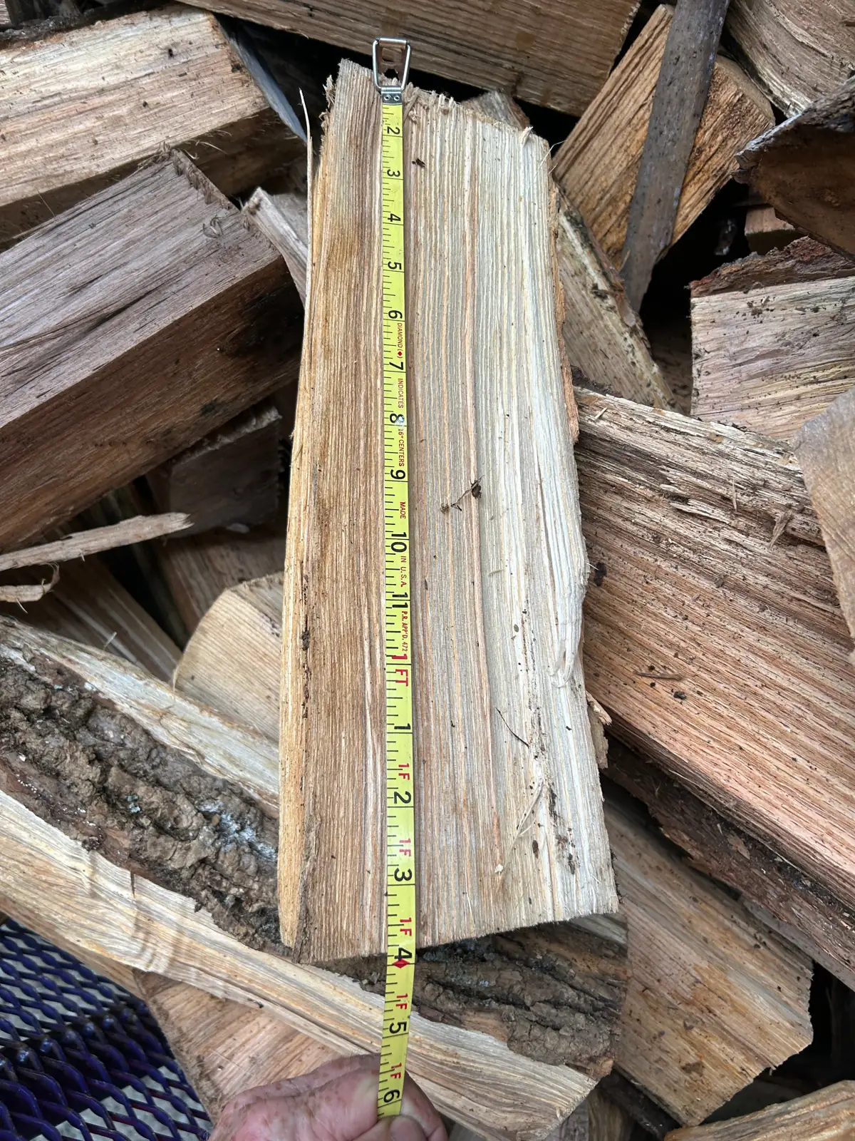 A tape measure laid along a split of seasoned hardwood showing its length